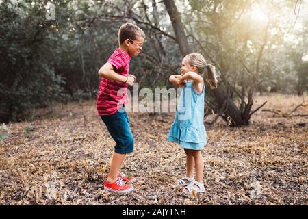 Two kids playing and dancing in the forest Stock Photo