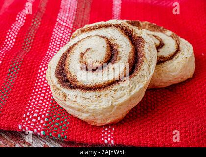 Traditional homemade cinnamon buns on a red tablecloth. Stock Photo