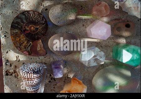 Crystals stones and seashells in light shadow and rainbow light. Natural object still life photography. Stock Photo