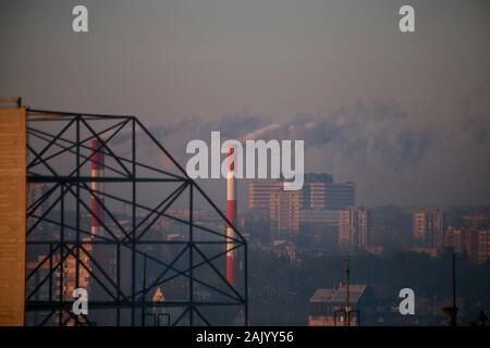 Smoking from industrial chimneys of heating plant emits smoke, smog, pollutants enter atmosphere. Harmful emissions, exhaust gases into air. Heating. Stock Photo
