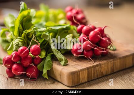 Fresh bundles of radish laid on a kitchen table
