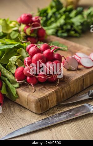 Fresh bundles of radish laid on a kitchen table Stock Photo