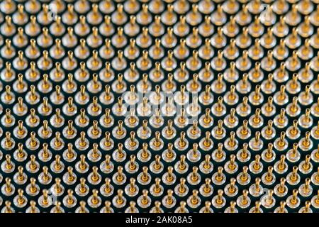Close-up full frame view of gold plated microprocessor pin array. Abstract electronic technological background with selective focus. Stock Photo