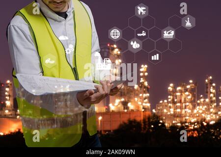 Engineer is working and holding a blueprint in hand and icon connecting networking,Industry Refinery concept image Stock Photo