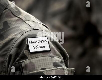 Fake News Soldier. Inscription Fake News Soldier on military uniform. Fake News Soldier Concept. Digital War. Stock Photo