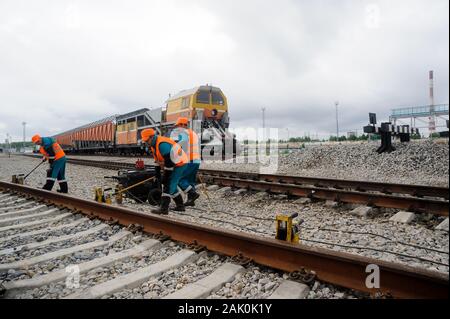 Railway workers repairing rail in rain Stock Photo
