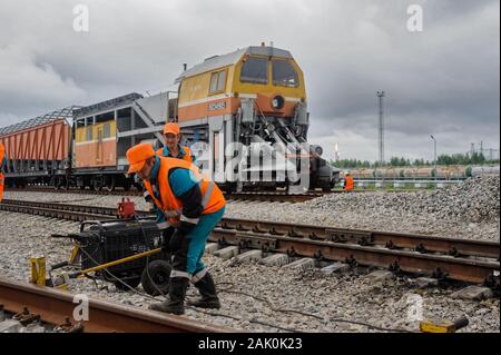 Railway workers repairing rail in rain Stock Photo