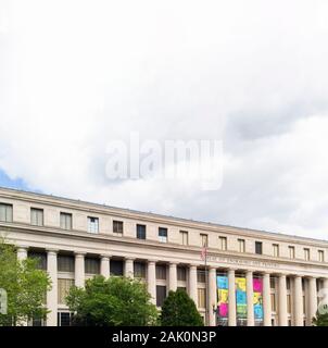 Washington DC, USA - June 22, 2019: Exterior view of Bureau of Engraving and Printing building facade entrance with cloudscape sky. Stock Photo