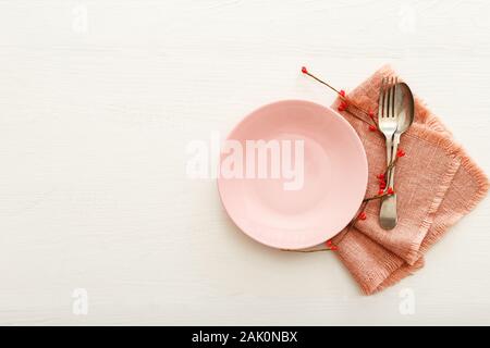 Valentines Day festive table setting on a white wooden table. Dinner meal in restaurant at Valentine Day. Two red hearts on pink plate. Valentine Day Stock Photo