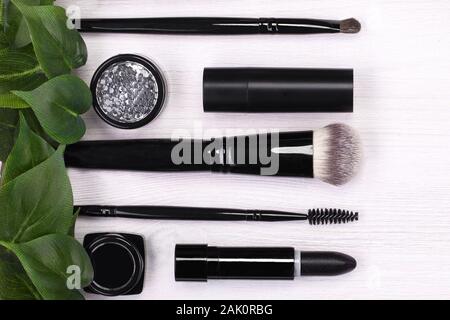 Set of brushes and cosmetic products in a cosmetic bag on a white background. Stock Photo