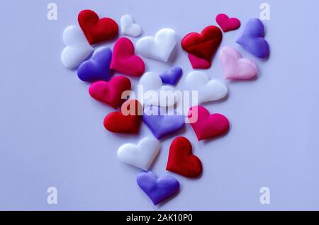 Hearts in different colors and sizes on white background from above Stock Photo