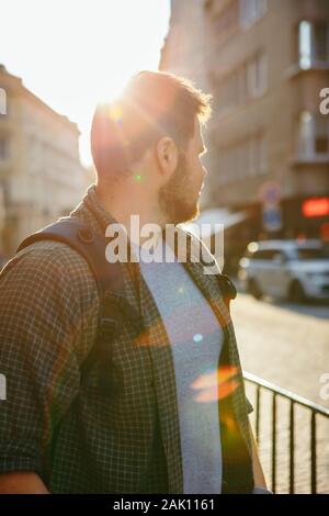 young bearded man at city street sunset Stock Photo
