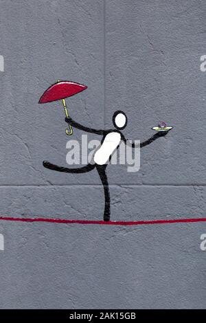 Street art of a figure balancing on a line, holding umbrella and dish, Palma, Mallorca, Spain Stock Photo