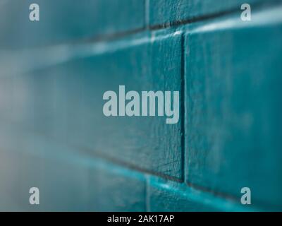 A brick wall painted in turquoise in a street in Shoreditch, London Stock Photo