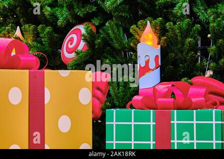 Gift boxes against the background of candles and Christmas tree. Close up. Stock Photo