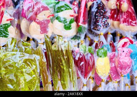 Lots of packaged sweets. Lollipops, candy in different figurines. Close up. Stock Photo