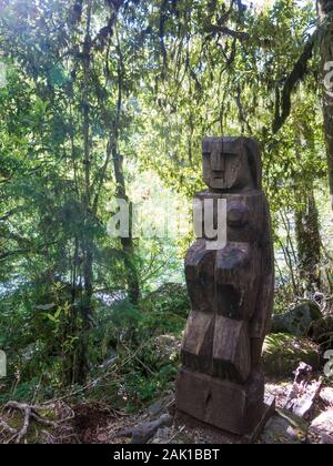 Wooden statue, in the middle of the Huilo Huilo Biological Reserve, regressing animals and Mapuche mystical characters from southern Chile. Los Ríos R Stock Photo