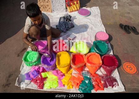A boy selling powdered paint for the festival of Holi in the old city of Delhi, India Stock Photo