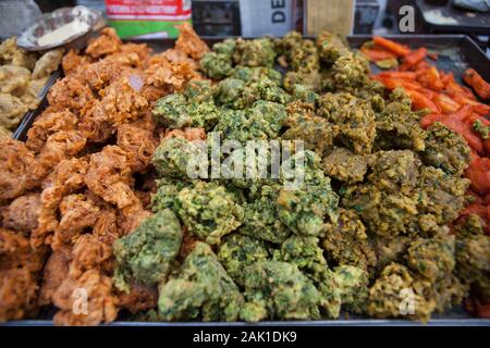 Fried chilli pakoras and onion bhajis on display at a street stall in the old city of New Delhi, India Stock Photo