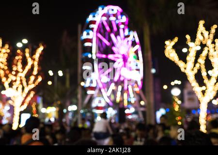 Defocused and blurred photo of people in the night amusement park, used for background or backdrop concept. Stock Photo