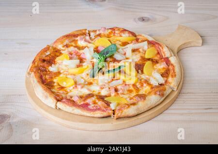 Hawaiian pizza with pineapple and ham on wooden table Stock Photo