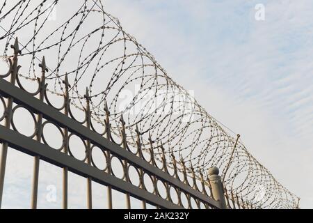 rusty barbed wire fence in sunny day Stock Photo