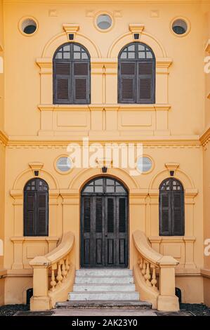 JAN 13, 2019 Udon Thani, Thailand - Grand historic Yellow French Colonial building artisan window and door frames with classic entrance of Udon Thani Stock Photo