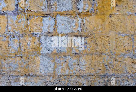 Old grunge brick wall painted yellow color of background and texture. Stock Photo