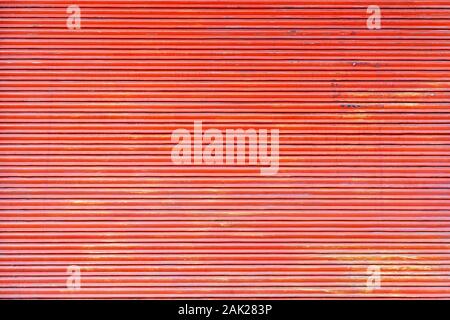 Red color rolling steel shutter door background. Stock Photo