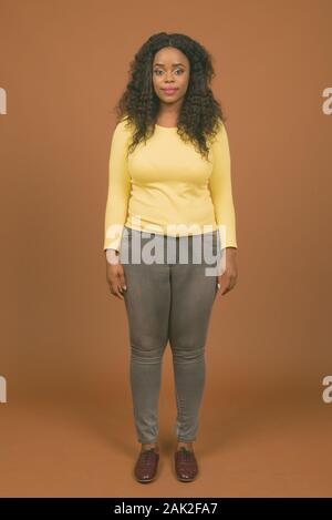 Young beautiful African woman against brown background Stock Photo