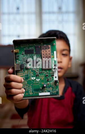 Smart Asian Boy working on Electronic Circuitry at home Stock Photo