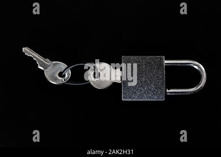 Padlock with keys close-up on a black background. Stock Photo