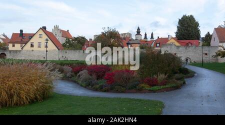 VISBY, SWEDEN ON OCTOBER 11, 2019. View of Almedalen park this side the City Wall. Unidentified person. Old buildings. Editorial Stock Photo