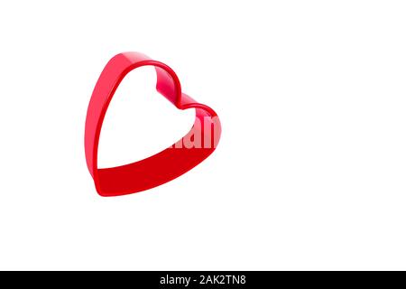 Red plastic heart shaped for dough in bakery. Concept of love and Valentines Day. Isolated on white. Close-up. Stock Photo