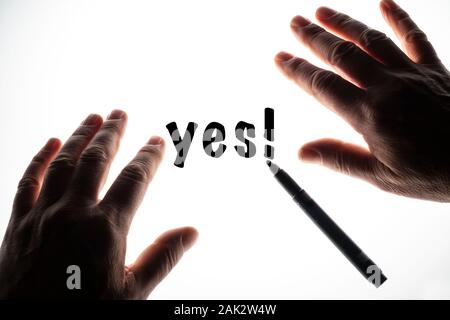 the word Yes written on a backlit surface Stock Photo