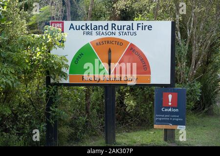 Auckland Rural Fire season status warning sign native bush roadside, permit only restricted, Piha, Waitakere Ranges, West Coast, pest control caution Stock Photo