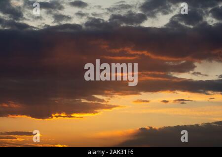 Sunrise time with dramatic dark clouds at sky, golden hour horizontal shot Stock Photo