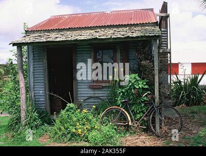 A rusty bicycle rests on a simple house that was built by the early settlers in the Pioneer Village of Stratford. Stratford is situated on the North I Stock Photo