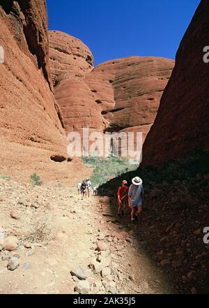 People walk through the Valley of the Winds in the Kata Tjuta (Olgas). The Kata Tjuta (Olgas) are located in the Uluru - Kata Tjuta National Park near Stock Photo