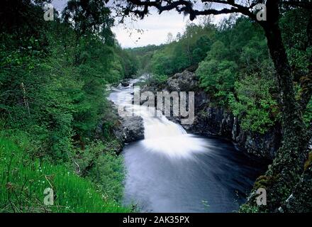 In picturesque cascades the River Shin rushes down the rocks in the hinterland of Dornoch. The Falls of Shin are situated in the Scotish Highlands in Stock Photo