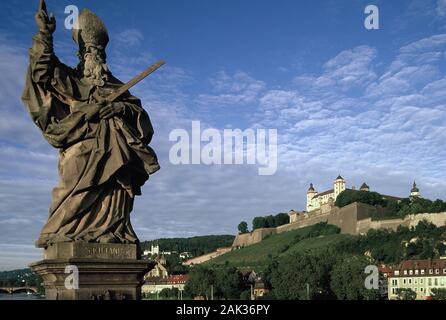 View of a St. Kilian statue on the Old Main Bridge and in the backround of the fortress Marienberg in Würzburg in (undated picture) | usage worldwide Stock Photo