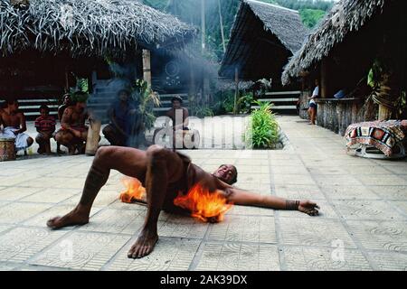 A local performing the famous fire dance in the Tiki Village Theater on the island of Moorea in French Polynesia. The Tiki Village Theater is a copied Stock Photo