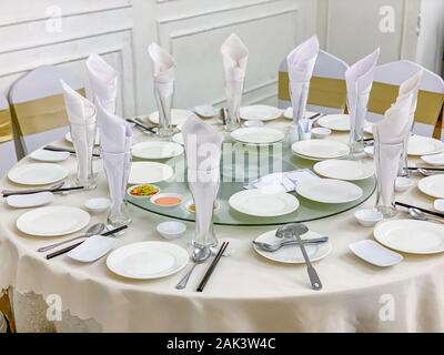 Elegant white banquet round dinner table in wedding hall Stock Photo