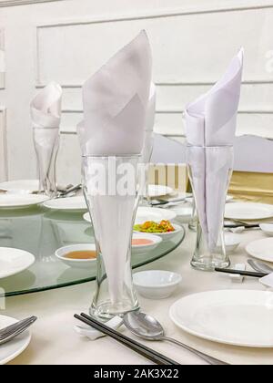 Elegant banquet table setting with glass and white ceramic tableware  Stock Photo