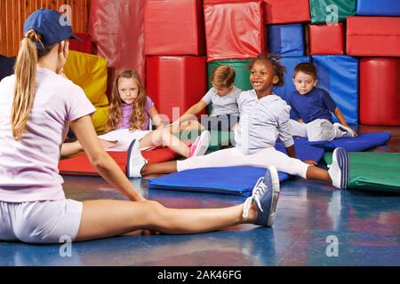 Children do gymnastics at the Kindergarden in kindergarten together with the kindergarten teacher Stock Photo