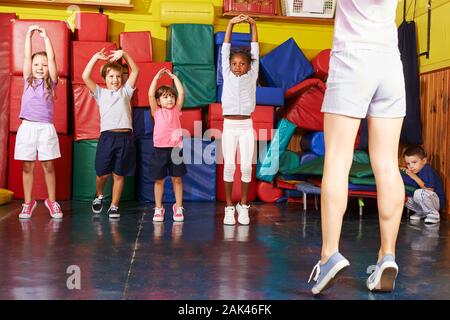 Happy group of kids together while kid sports in preschool Stock Photo