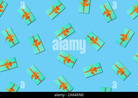 Holiday card. Mint gift boxes with orange ribbon on blue background. Flat lay, top view. Stock Photo