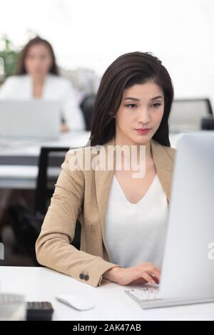 Chinese businesswomen using computer in office Stock Photo