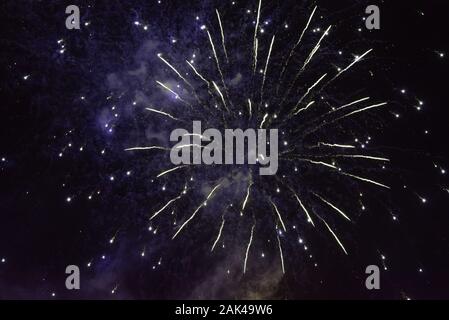 A burst of fireworks, with a bluish tint, against the background of the night sky. Stock Photo