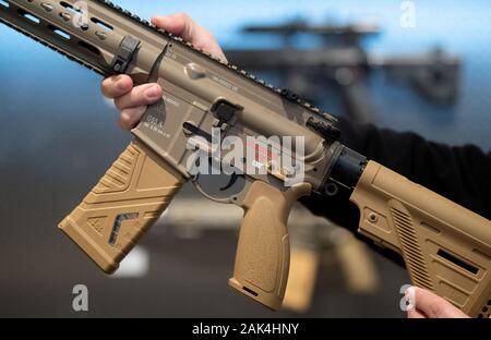 Oberndorf Am Neckar, Germany. 18th Dec, 2019. An employee of the weapons manufacturer Heckler & Koch holds a G95K assault rifle in his hands in a presentation room. Credit: Marijan Murat/dpa/Alamy Live News Stock Photo